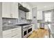 Modern kitchen featuring stainless steel appliances, marble backsplash, granite counters and white cabinets at 12999 Deerstyne Green St, Carmel, IN 46032
