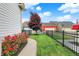 Landscaped pathway with rose bushes and a red tree along a black metal fence at 12999 Deerstyne Green St, Carmel, IN 46032