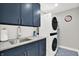 Well-equipped laundry room with modern washer and dryer, sink, and cabinet space at 12999 Deerstyne Green St, Carmel, IN 46032