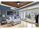 Inviting living room featuring hardwood floors, backyard access, a comfortable sofa, and wood ceiling with modern fan at 12999 Deerstyne Green St, Carmel, IN 46032