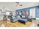 Open-concept living room with hardwood floors, comfortable sofas, ottoman, modern ceiling fan, and view to the kitchen at 12999 Deerstyne Green St, Carmel, IN 46032