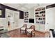 Elegant living room featuring custom built-ins, a cozy seating area, and French doors for added privacy at 12999 Deerstyne Green St, Carmel, IN 46032
