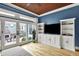Bright living room with hardwood floors, backyard access, custom built-ins, and a view to the backyard at 12999 Deerstyne Green St, Carmel, IN 46032