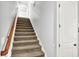 Carpeted staircase with wooden handrail and white trim offers access to upper level at 12999 Deerstyne Green St, Carmel, IN 46032