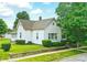 Charming single-story home featuring mature trees, green lawn, and concrete retaining wall at 1331 S 9Th St, Noblesville, IN 46060