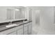 Bathroom featuring double vanity with grey countertops and white cabinets, marble floors and shower, and walk-in closet at 1354 Sambar Ct, Greenwood, IN 46143