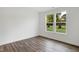 Well-lit bedroom featuring wood floors, white walls and large windows with views of the lush greenery outside at 1354 Sambar Ct, Greenwood, IN 46143