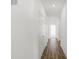 Hallway with hardwood floors and white doors leading to different rooms, illuminated by recessed lighting at 1354 Sambar Ct, Greenwood, IN 46143