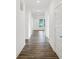 Hallway featuring hardwood floors and white walls, leading to various rooms with natural light streaming in from windows at 1354 Sambar Ct, Greenwood, IN 46143