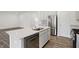 Kitchen island with a stainless steel sink, dishwasher, and white cabinets, providing a functional workspace in the open-concept kitchen at 1354 Sambar Ct, Greenwood, IN 46143