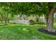 Lush front lawn, mature shade tree, and white picket fence frame this charming townhouse in a quiet neighborhood at 150 Dominion Dr, Zionsville, IN 46077