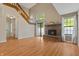 Open living room floorplan with a staircase, brick fireplace, natural light, and wood-look flooring at 150 Dominion Dr, Zionsville, IN 46077