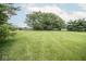 Expansive backyard with manicured lawn, mature trees, and a charming home, creating a serene and private outdoor space at 22620 Lamong Rd, Sheridan, IN 46069