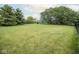 Lush green backyard with mature trees, offering a peaceful and expansive outdoor space perfect for recreation and relaxation at 22620 Lamong Rd, Sheridan, IN 46069