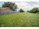 Large, green backyard enclosed by a wooden fence, providing a secure and private outdoor space for various activities at 22620 Lamong Rd, Sheridan, IN 46069
