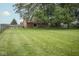 A serene backyard featuring a well-kept lawn, privacy fence, and mature trees offering ample shade and seclusion at 22620 Lamong Rd, Sheridan, IN 46069