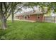 Brick home exterior showcasing a spacious backyard with a wooden deck, ideal for outdoor relaxation and entertainment at 22620 Lamong Rd, Sheridan, IN 46069