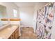 Bathroom featuring a sink, a toilet, a colorful shower curtain, tile flooring, and a window at 22620 Lamong Rd, Sheridan, IN 46069