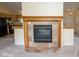 Living room fireplace with wood mantle and decorative tile surround with kitchen in the background at 22620 Lamong Rd, Sheridan, IN 46069