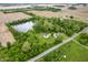Aerial view featuring the home, barn, pond, and surrounding green landscape at 2708 N 400 E, Greenfield, IN 46140