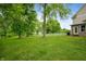 Lush backyard with mature trees and a white picket fence creating a serene outdoor space at 2708 N 400 E, Greenfield, IN 46140