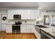 Modern kitchen with stainless steel appliances, granite countertops, and white cabinets at 2708 N 400 E, Greenfield, IN 46140