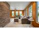 Cozy living room featuring a brick accent wall, wood flooring, a ceiling fan and bright windows at 2708 N 400 E, Greenfield, IN 46140