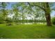 Picturesque pond with two Adirondack chairs nestled under a large shade tree at 2708 N 400 E, Greenfield, IN 46140