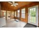 Bright sunroom with wood paneled ceiling and walls, white trim and an exterior door at 2708 N 400 E, Greenfield, IN 46140