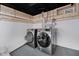 The finished basement has modern washer and dryer units and painted concrete floor at 2909 E Michigan St, Indianapolis, IN 46201