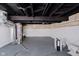 Unfinished basement featuring painted floors and exposed ceiling and duct work at 2909 E Michigan St, Indianapolis, IN 46201