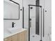 The updated bathroom has a tile shower with a glass door, modern vanity, and black fixtures at 2909 E Michigan St, Indianapolis, IN 46201