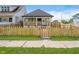 Charming home featuring a cozy front porch and a well-maintained lawn with a decorative wooden fence at 2909 E Michigan St, Indianapolis, IN 46201