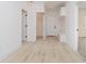 Hallway with coat rack and view of rooms and light wood-style flooring at 2909 E Michigan St, Indianapolis, IN 46201