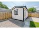 Backyard shed with white siding, black trim, new roof, and level gravel base at 2909 E Michigan St, Indianapolis, IN 46201