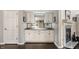 A stylish home bar with white cabinets, a mirrored backsplash, and a granite countertop at 2949 River Bay N Dr, Indianapolis, IN 46240