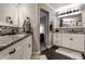 This bathroom includes double sinks, stone countertops, tile backsplash, and modern fixtures and lighting at 2949 River Bay N Dr, Indianapolis, IN 46240