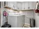 Bright laundry room includes ample cabinet space for storage and a modern washer and dryer at 2949 River Bay N Dr, Indianapolis, IN 46240