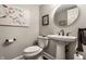 A cozy powder room with a pedestal sink, round mirror, and decorative bird artwork at 2949 River Bay N Dr, Indianapolis, IN 46240
