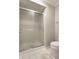 Bathroom featuring a sliding glass door shower next to a toilet with white tile floor at 2949 River Bay N Dr, Indianapolis, IN 46240