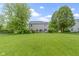 Spacious backyard featuring a lush lawn, mature trees, and a deck at 3014 Saddlehorn Dr, Carmel, IN 46033