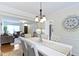 Open-concept dining room with a white table, upholstered chairs, and an open view of the living room at 3014 Saddlehorn Dr, Carmel, IN 46033