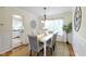 Elegant dining room with a white table, upholstered chairs, and modern lighting fixture at 3014 Saddlehorn Dr, Carmel, IN 46033