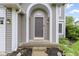 Close-up of an arched doorway, showing a stylish front door with sidelights and exterior lighting at 3014 Saddlehorn Dr, Carmel, IN 46033