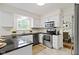 Well-lit kitchen featuring stainless steel appliances, black countertops, and a window overlooking the backyard at 3014 Saddlehorn Dr, Carmel, IN 46033