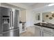 Spacious kitchen with stainless steel refrigerator, black countertops, wine rack, and tile flooring at 3014 Saddlehorn Dr, Carmel, IN 46033