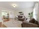 Bright living room with hardwood floors, neutral-colored furniture, and an open view of the dining area at 3014 Saddlehorn Dr, Carmel, IN 46033