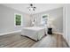 Neutral bedroom with ceiling fan, featuring two large windows and wood-look flooring at 3334 N Chester Ave, Indianapolis, IN 46218