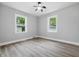 Bright bedroom with hardwood floors, complemented by two windows offering scenic outdoor views at 3334 N Chester Ave, Indianapolis, IN 46218