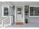 Close up of a freshly painted door with black hardware, a Welcome mat, and an exterior light at 3334 N Chester Ave, Indianapolis, IN 46218